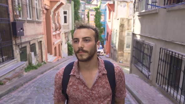 Young man walking on the cobblestone street.