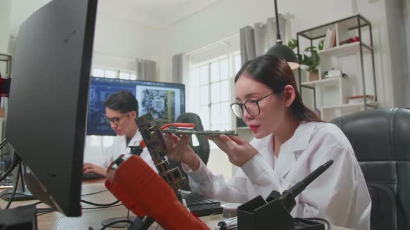 Asian Female Engineer Inspects Printed Circuit Board Motherboard. Scientist Designs Industrial Pcb