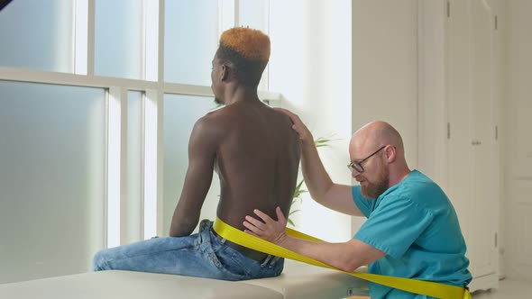 A Physical Therapist Safely Trains a Patient Using Medical Exercise Equipment