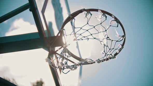 A Basketball Hoop. The Net Fluttering in the Wind. Bright Sunlight