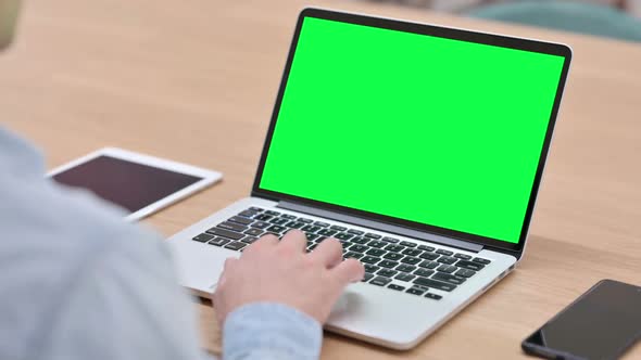 Man Working on Laptop with Green Chroma Key Screen