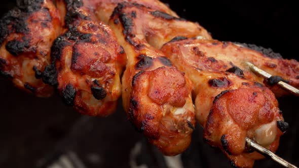 Closeup of Delicious Grilled Chicken Wings on the Skewers Frying Above the Fire