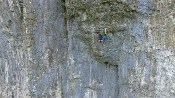 Aerial view of a man rock climbing up a mountain