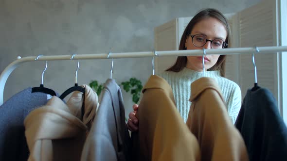 Beautiful Woman in Glasses Chooses Clothes for a Business Meeting