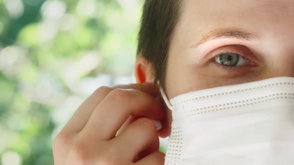 Female Woman with Wireless Headphones in a Medical Protective Mask Online Listening Music During