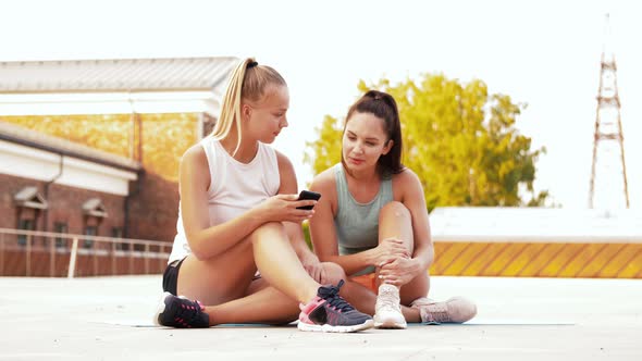 Sporty Women or Friends with Smartphone on Rooftop