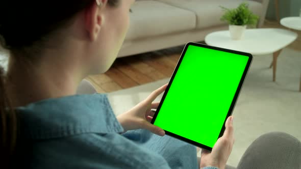 View From the Shoulder of Woman Holding and Using Hand Gestures on Green Mock-up Screen Digital