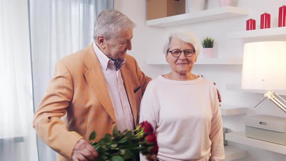 Old Man Surprising His Wife with Bouquet of Red Roses