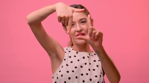 Pretty Woman Shows Hands the Shape of a Photo Frame in Front of the Camera.