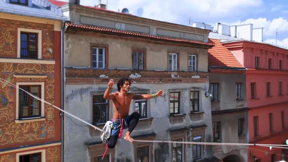 Man Balances on Tight Rope a View of the City From Height