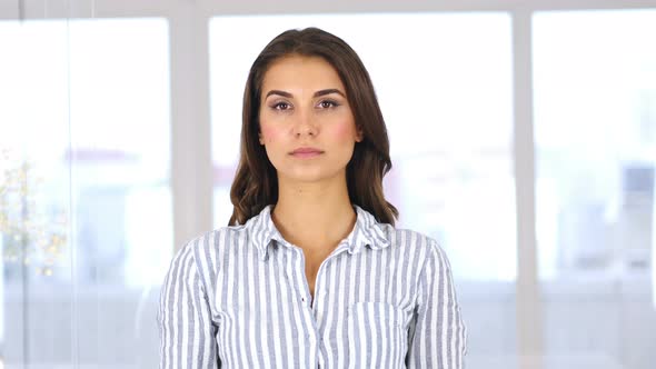 Beautiful Hispanic Woman Sitting in Office, Looking at Camera