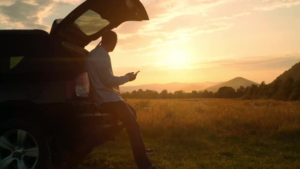 Man Photographs the Landscape Traveling By Car