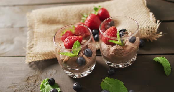 Video of chocolate pudding with strawberries and bluberries on a wooden surface