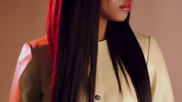 Beautiful Girl with Red Lips and Long Black Hair in a Yellow Leather Coat Turns Her Head