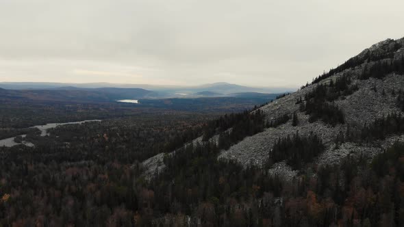 Aerial View of the River of Stones Among the Dense Coniferous Forest and the Top of the Mountain