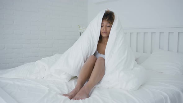 Sleepy Woman Cuddling in Blanket