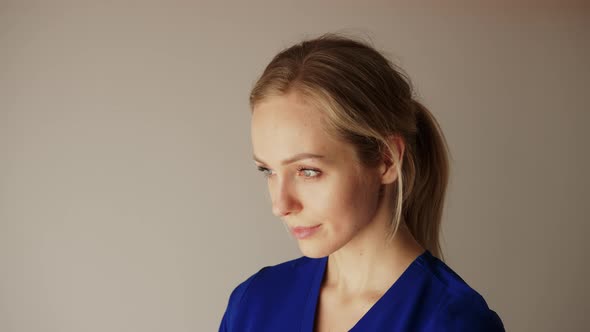 Beautiful Caucasian Blonde Woman in a Royal Blue Uniform Softly Looking Up