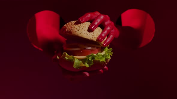 Close Up of Tasty Cheeseburger in Beautiful Woman Red Hands