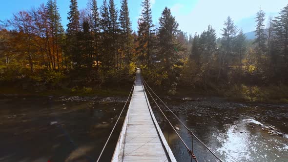 Cinematic Aerial Slow Motion Broll Shot of Wooden Suspension Bridge Hanged Over Mountain River