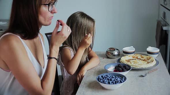 Happy Mom and Daughter Having Breakfast Together