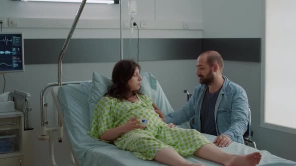 Caucasian Pregnant Woman Sitting in Hospital Ward Bed