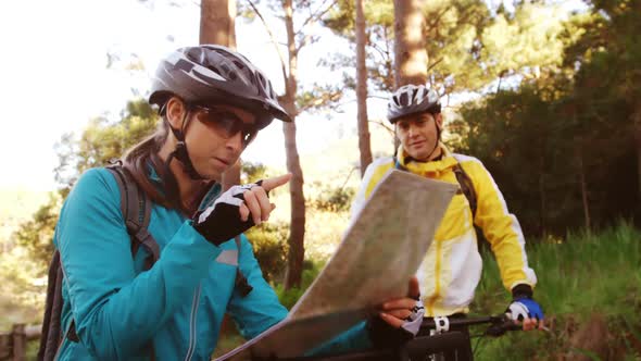 Mountain biking couple looking at map