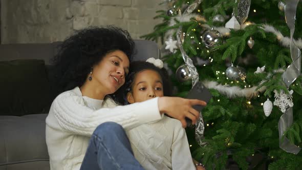 Portrait of African American Mom and Her Little Daughter Having Fun and Taking Selfie Using