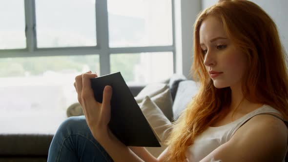 Woman reading a book in living room 4k