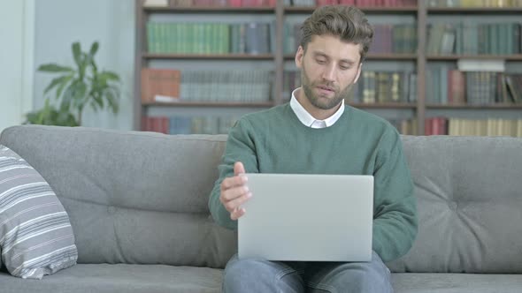 Young Man Putting His Laptop Away and Leaving