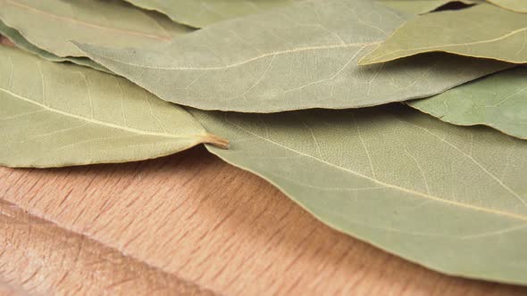 Seasoning bay leaf on a wooden surface macro shot. 