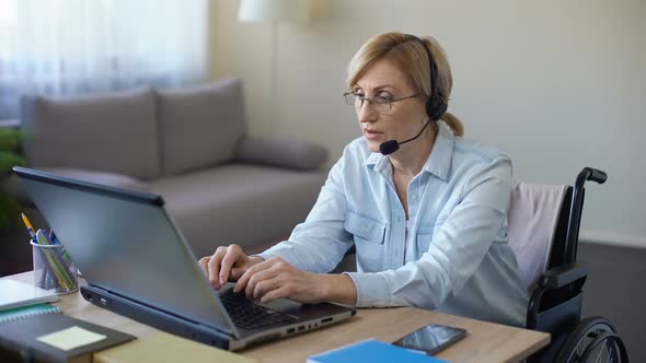 Disabled Female Manager Sitting at Office Desk, Working on Laptop From Home