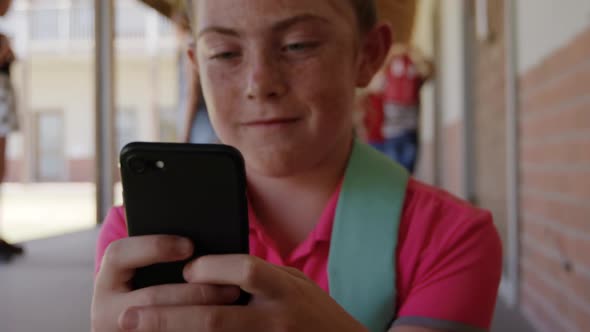 Girl using smartphone in the school corridor