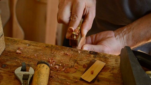 Luthier Sanding a Guitar Piece