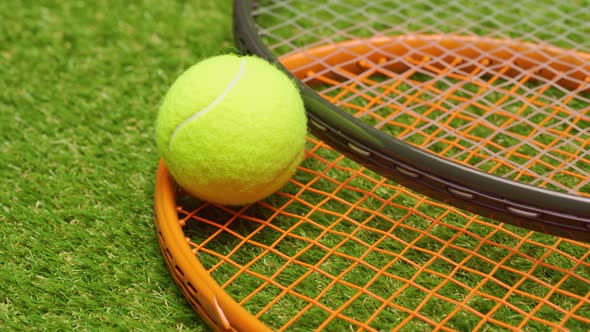 Tennis Balls and Racket on Green Grass Background Close Up