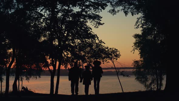 Parents Kid Silhouette Holding Hands Walking Together to River Sea Sunset Time