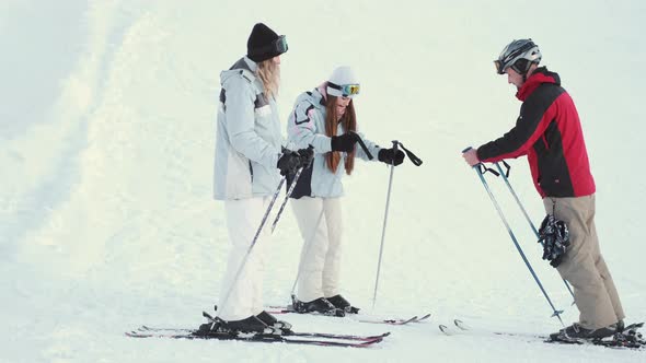 Ski Instructor Teaching Two Young Women Friends to Ski at Resort