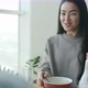 Happy Asian Woman Eating Cereal for Breakfast and Talking to Husband Smiling in Kitchen at Home - VideoHive Item for Sale