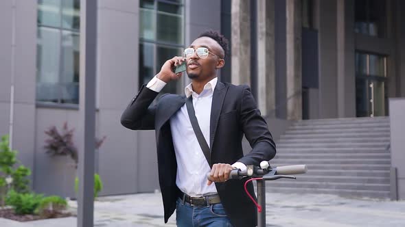 Modern Dark-Skinned Guy in Stylish Clothes and Sunglasses which Talking on Phone