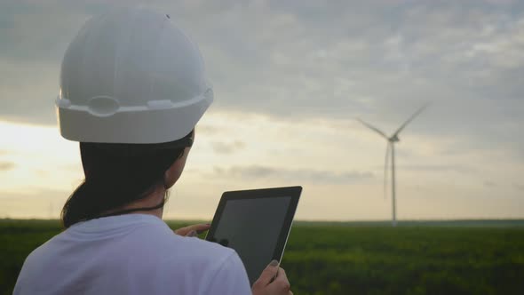 Woman Engineer Working in Wind Turbine Electricity Industrial at Sunset