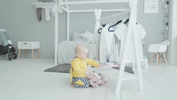 Cute Baby Learning To Stand Holding on Clothes alt