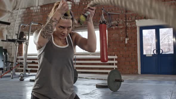 Muscular Woman Working Out with Ropes