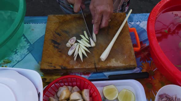 Woman cutting onions to be used in traditional Tom Yam Kung soup.