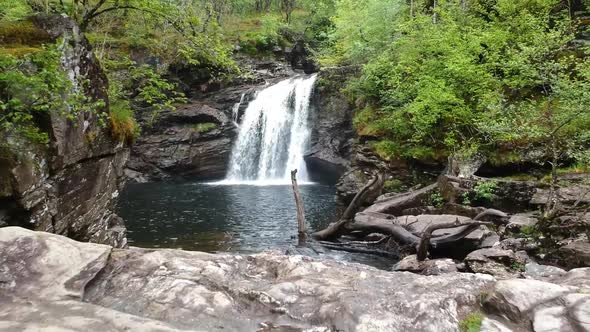 Revealing drone shot of mountain waterfall