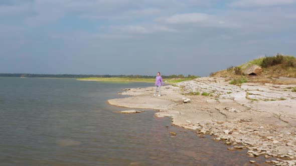 The Girl is Doing Fitness on the Lake Shore