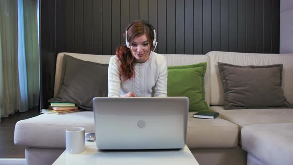 Young Smiling Laughing Lady Student Wearing Headphones Communicating By Video Call