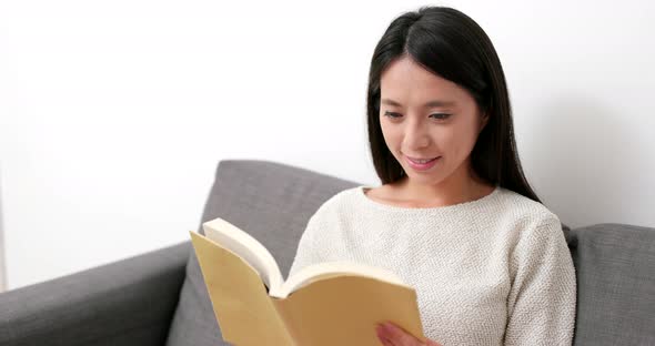 Young Woman reading book at home
