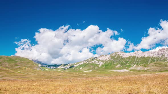 Time lapse: clouds moving in blue sky, sunny day on the mountains, view point over rocky mountain pe