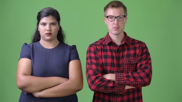 Young Multi-ethnic Business Couple Together Against Green Background