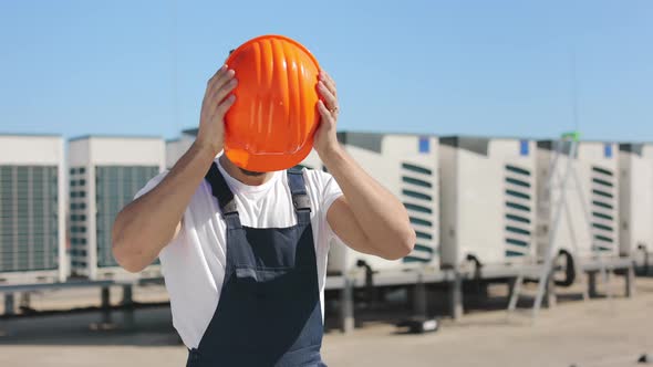 Portrait of a Young Engineer Who is Wearing a Protective Helmet on His Head and Crossing His Arms