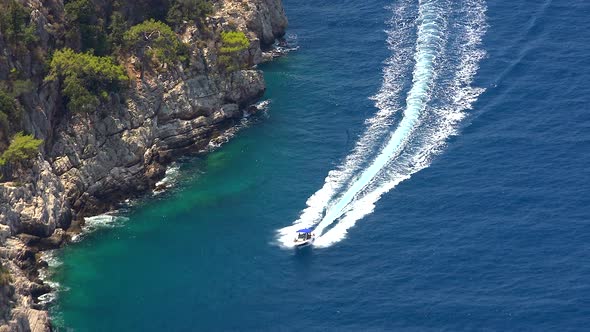 As A Speed Boat Sails At Sea, It Leaves Behind A White Sparkling Trail